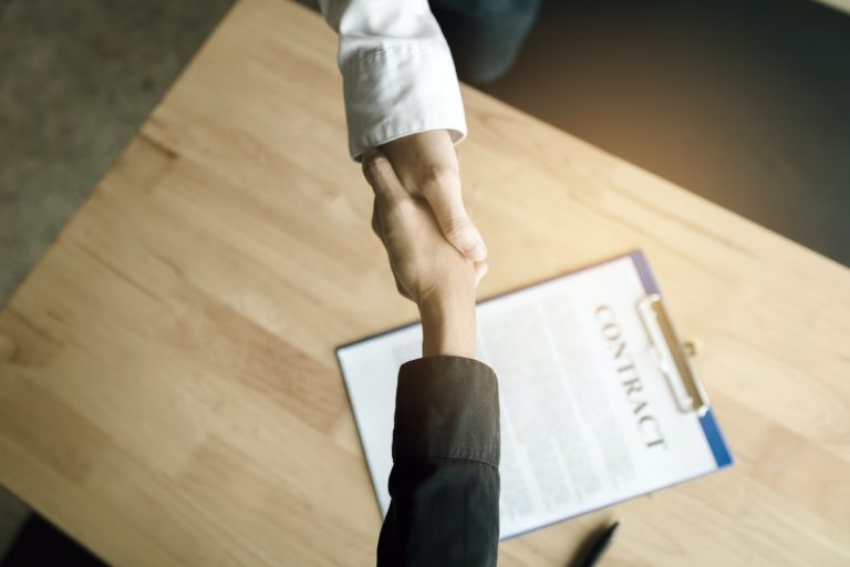 Business people shaking hands with making a contract in the office.